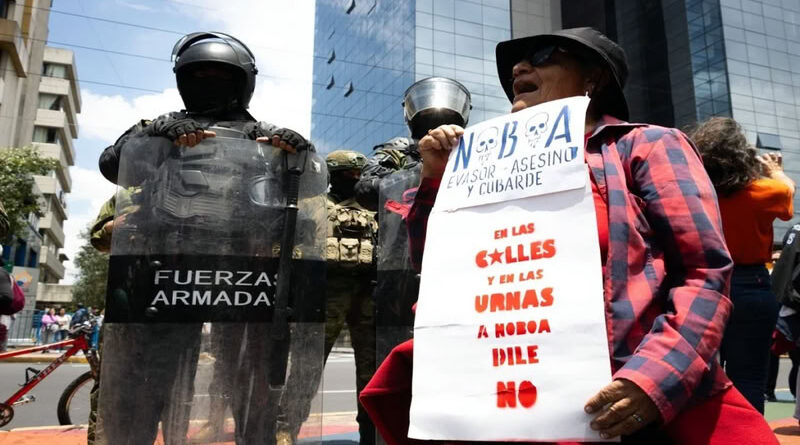 cartel que dice "Noboa evasor, asesino y cobarde"